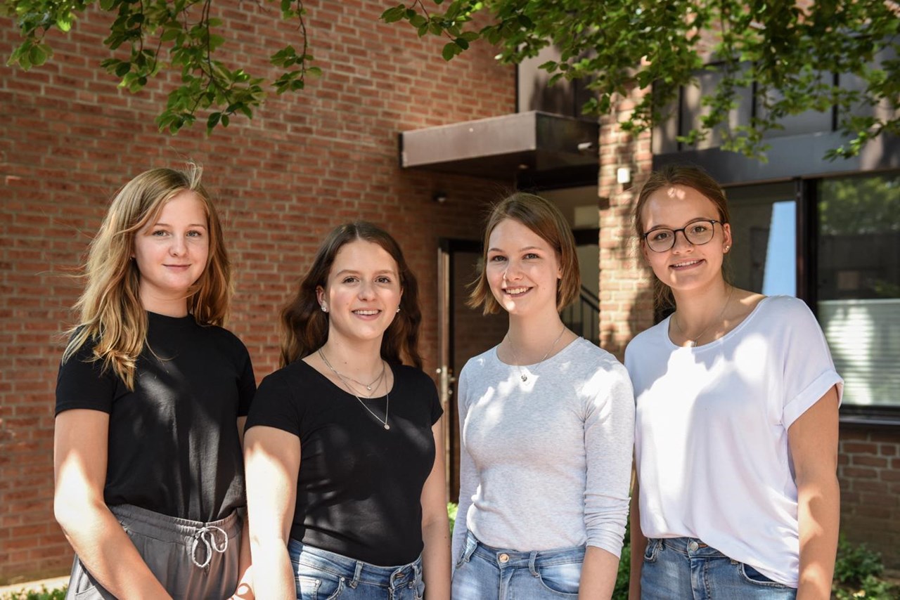 Vier junge Frauen blicken in die Kamera