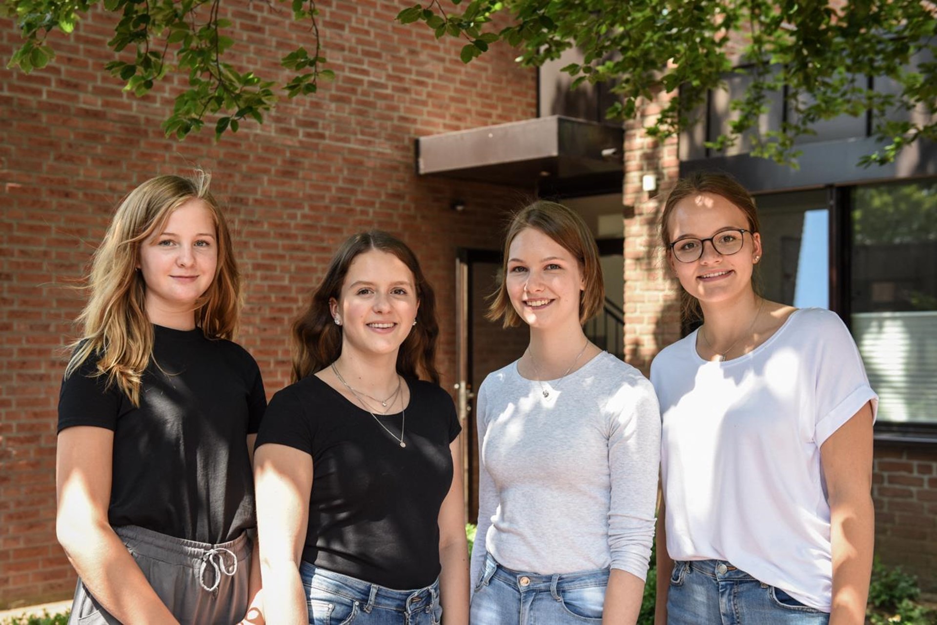 Vier junge Frauen blicken in die Kamera